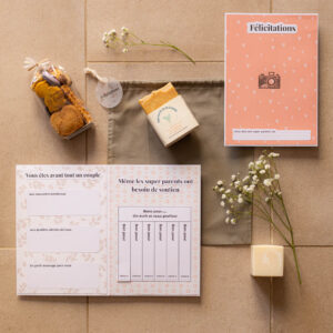 Kit de félicitations 100% local pour jeunes parents, composé d’un pochon vert sauge, de biscuits artisanaux, d’un savon naturel, d’un savon détachant et d’une carte de félicitations personnalisable, tous réalisés par des créateurs de l’Hérault.