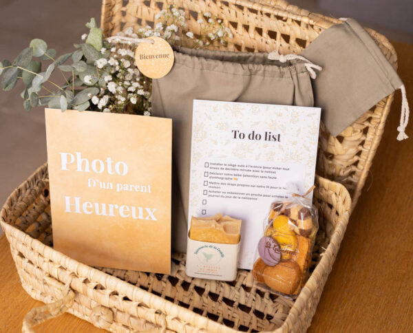 Vue d’ensemble du kit maternité co-parent présenté dans une valisette décorative (non incluse) : pochon vert sauge, mini-pochon, biscuits artisanaux, savon, et deux cartes artisanales, tous réalisés par des créateurs de l’Hérault.